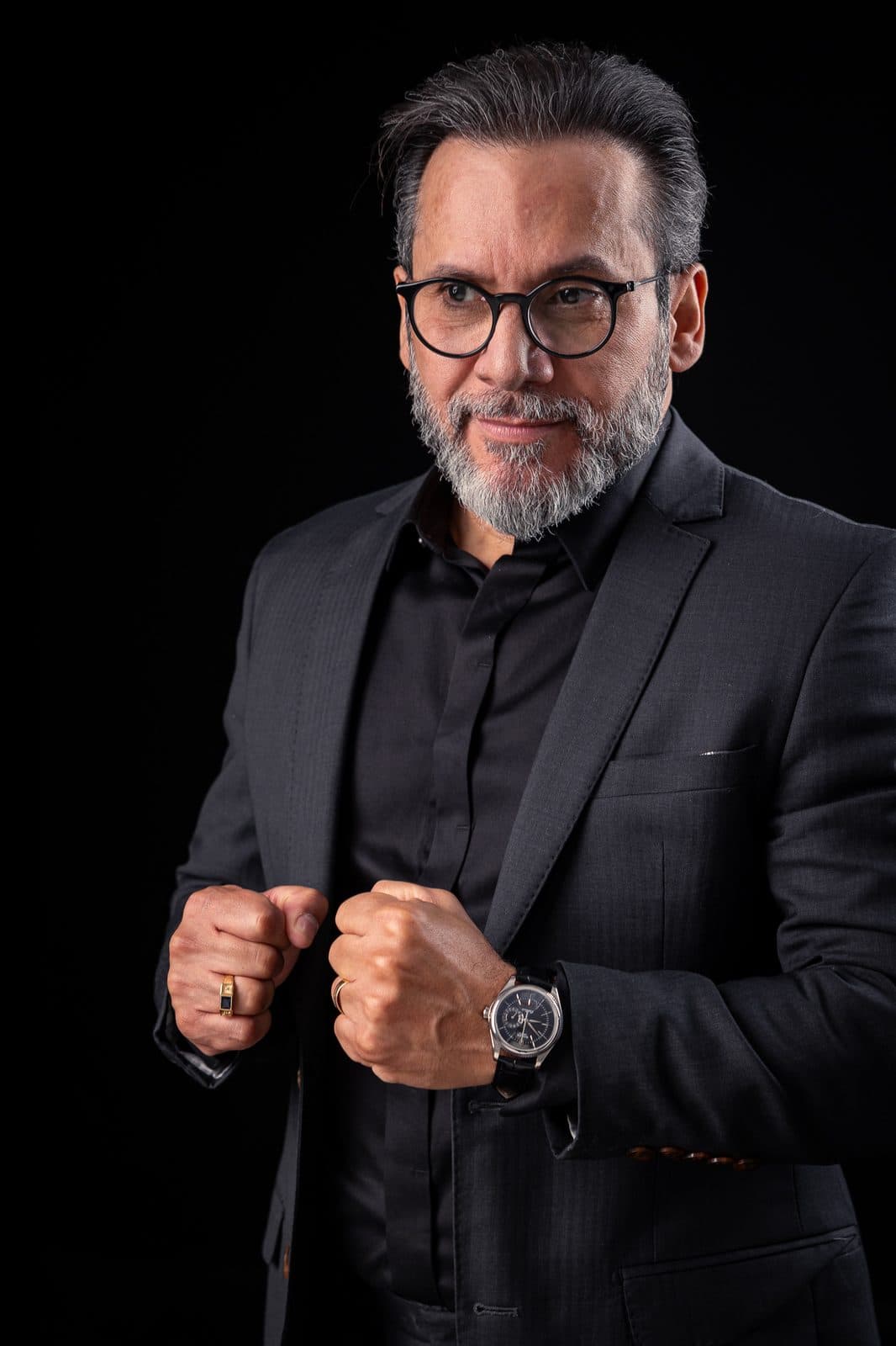 Gérson Rodrigues de terno preto, ajustando o punho da camisa